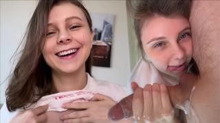 Брюнетка лежит между ног своего мужчины на постели и мастурб ирует